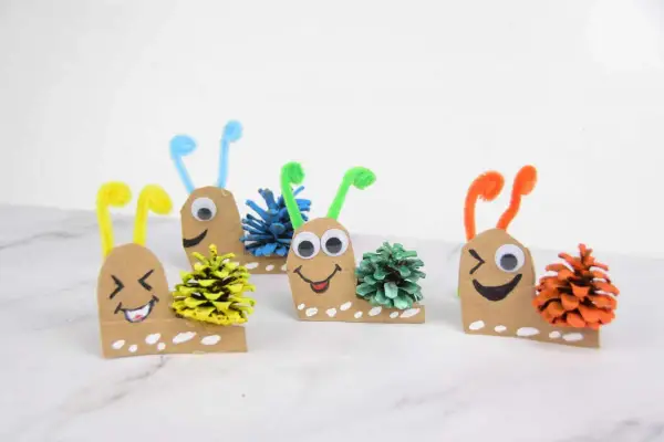Caracoles divertidos hechos con cartón y piñas, ideales para manualidades para niños de 8 a 12 años.